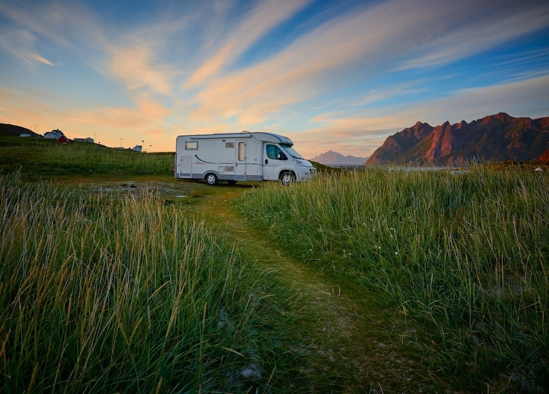 Wohnmobil auf einer Wiese vor einer eindrucksvollen Bergkulisse