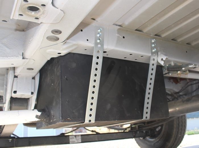 Schwarzer Grauwassertank unter einem Camper, mit Metallbändern befestigt